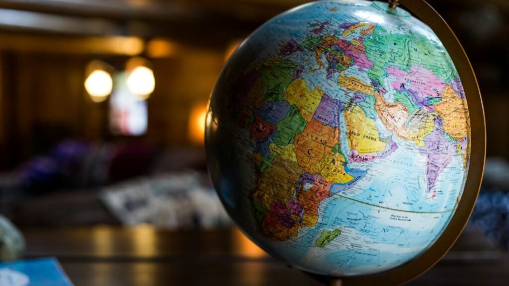 Globo terrestre sobre uma mesa, em um ambiente com luz quente ao fundo