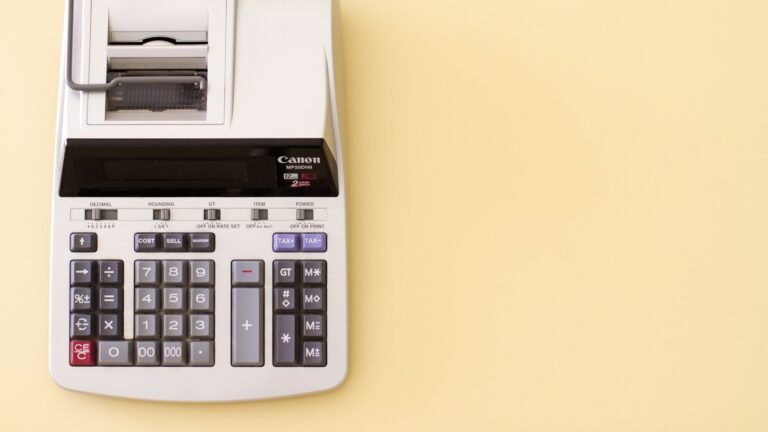 Calculadora de impressão com fita sobre fundo amarelo