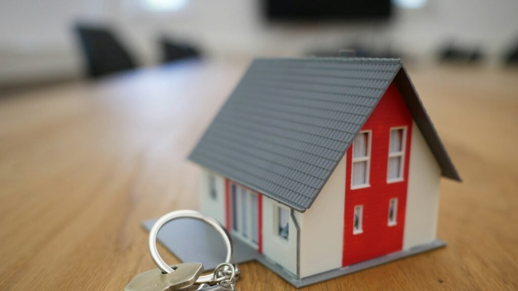 Miniatura de casa com chaves sobre a mesa